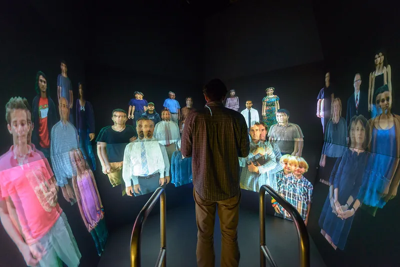 A visitor at the center of the CrowdCave surrounded by a projected crowd of composited figures